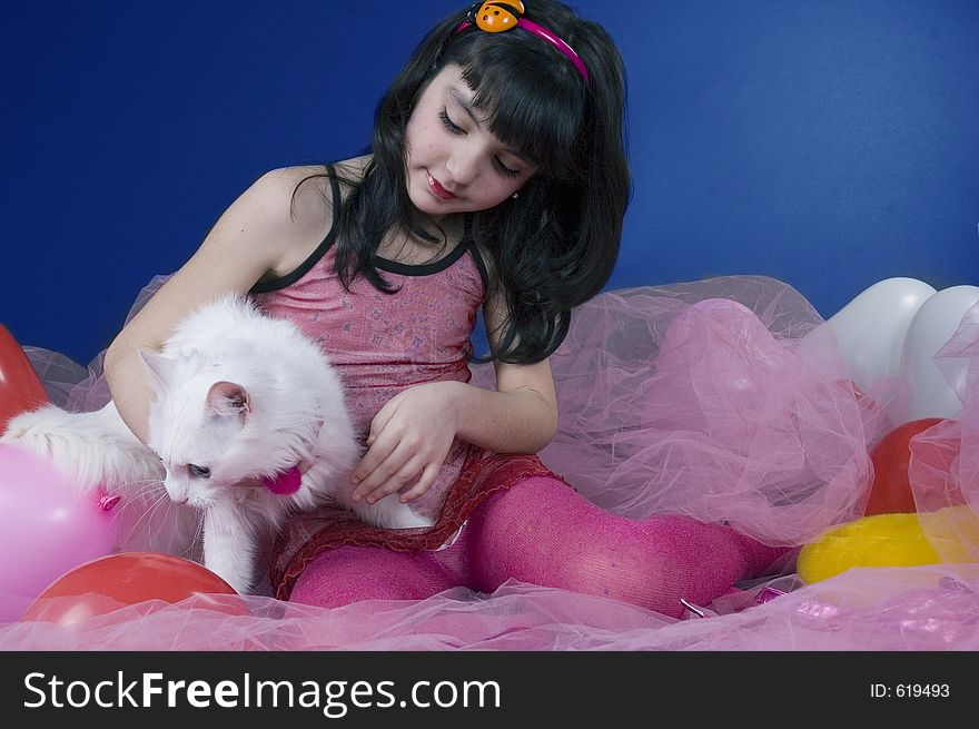 Pretty little girl playing with her white cat. Pretty little girl playing with her white cat