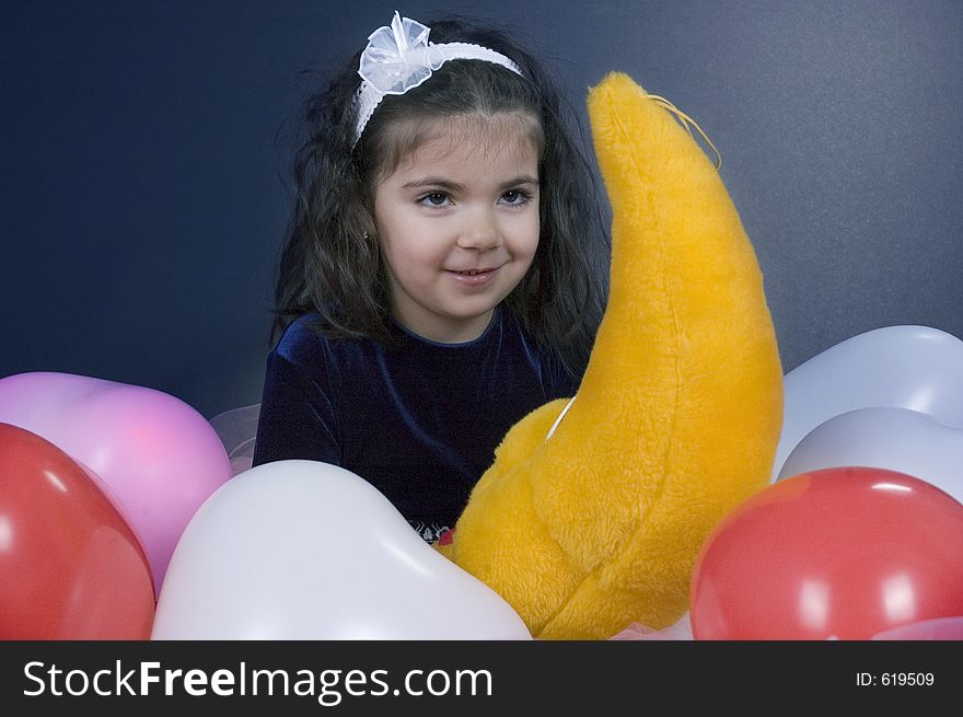 Pretty little girl with her moon toy surrounded by ballons. Pretty little girl with her moon toy surrounded by ballons