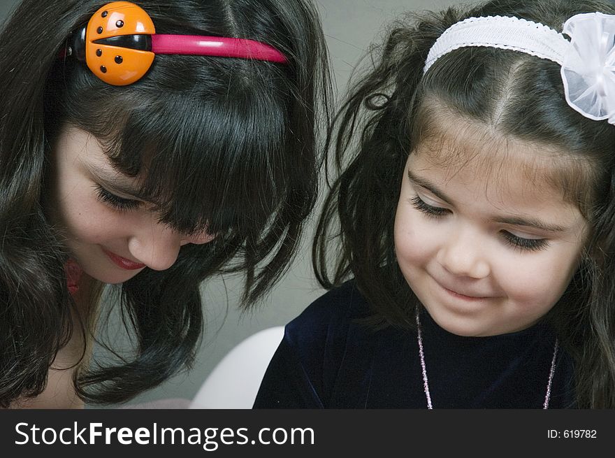 Two little girls focused on something. Two little girls focused on something