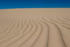 Rolling Sand Dunes On A Bright Blue Sky Royalty Free Stock Photos
