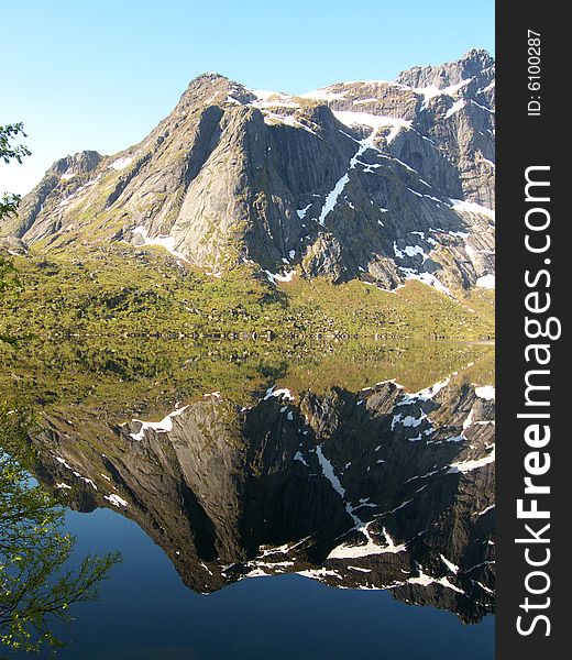 The mountains mirroring in the Storvatten lake, Lofoten islands. The mountains mirroring in the Storvatten lake, Lofoten islands