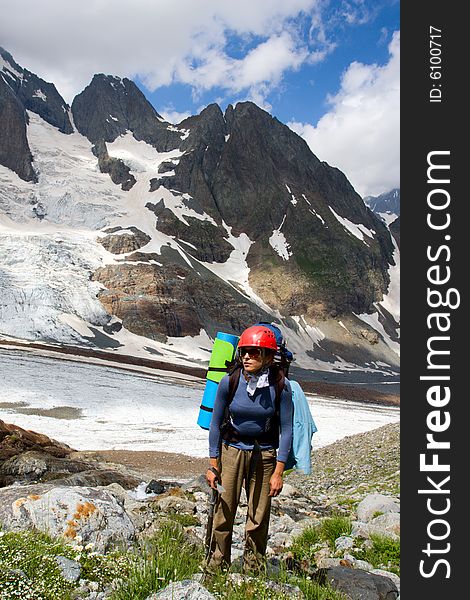 Traveller woman with ice-axe standing on flowering meadow. Traveller woman with ice-axe standing on flowering meadow