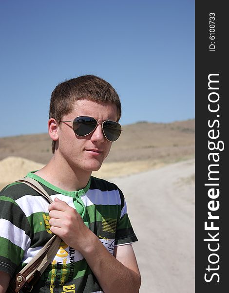 Young boy smiling with eyeglasses and bag.