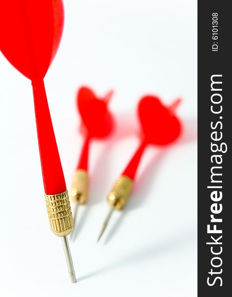 Three red darts on a white surface