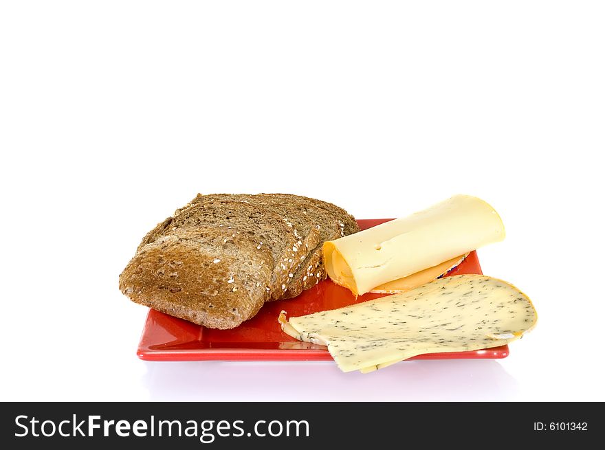 Bread and cheese on red platter, white background, reflective surface
