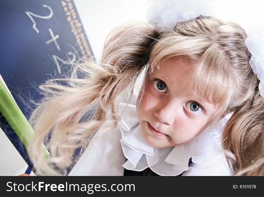 An image of Little girl standing near chalkboard. An image of Little girl standing near chalkboard.