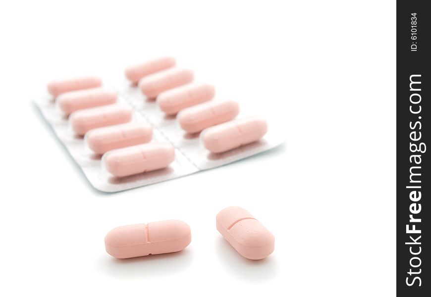Pink tablets on a white background.