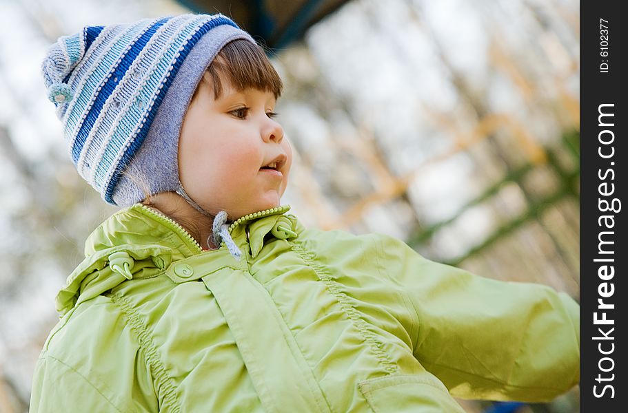 A cute chubby girl in a blue striped hat