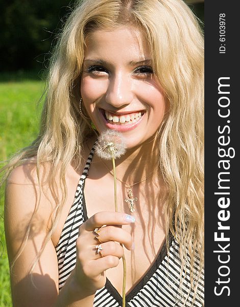 Beautiful girl with a dandelion in a hand