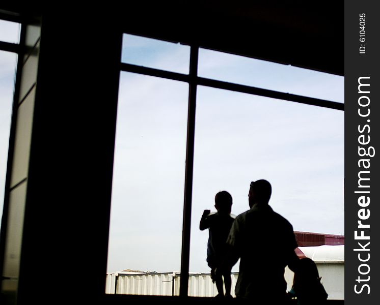 Silhouette of a father with son and daughter at the window. Silhouette of a father with son and daughter at the window