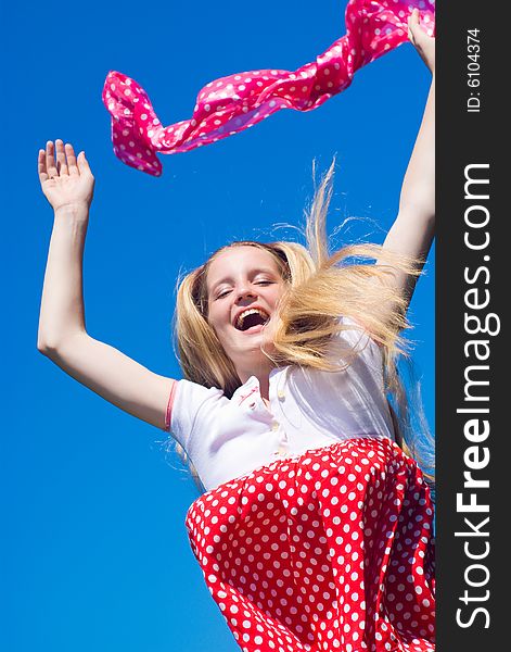 Happy jumping girl on blue sky background