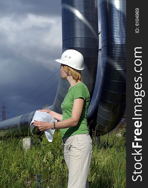 Woman engineer with white safety hat drawings