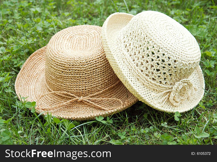 Pair of two straw raffia crocheted hats on grass. Pair of two straw raffia crocheted hats on grass