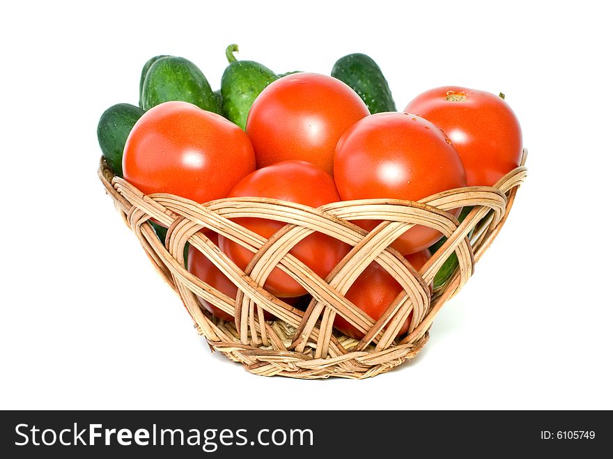 Basket with tomatoes and cucumbers isolated on the white background