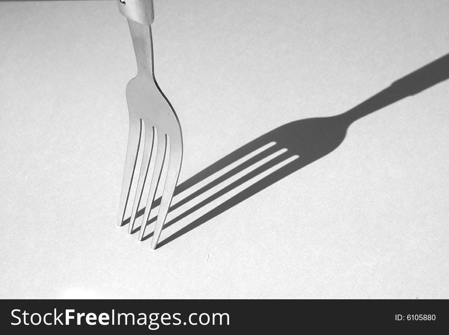 Photo of a fork and its shadow in black and white. Photo of a fork and its shadow in black and white.