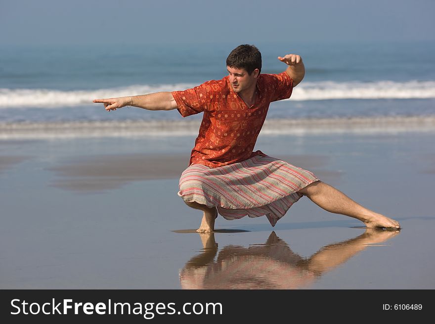 Man is doing east gymnastic on the beach