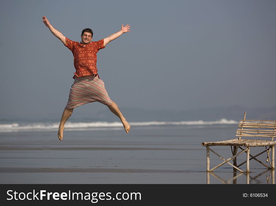 Man is jumping with a smile on the beach. Man is jumping with a smile on the beach