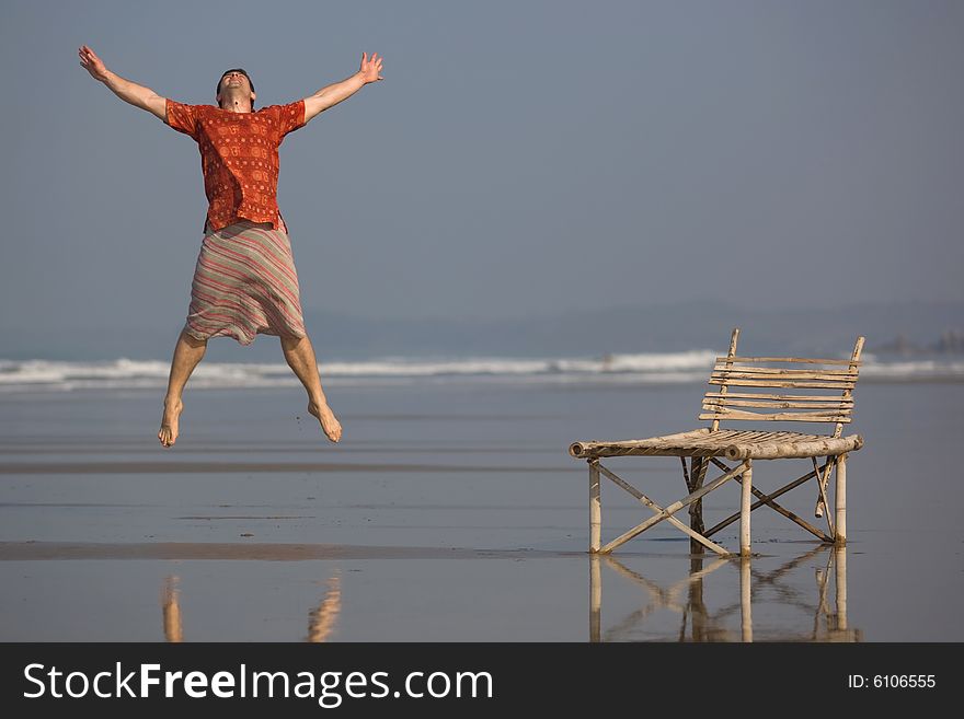 Man is jumping with a smile on the beach. Man is jumping with a smile on the beach