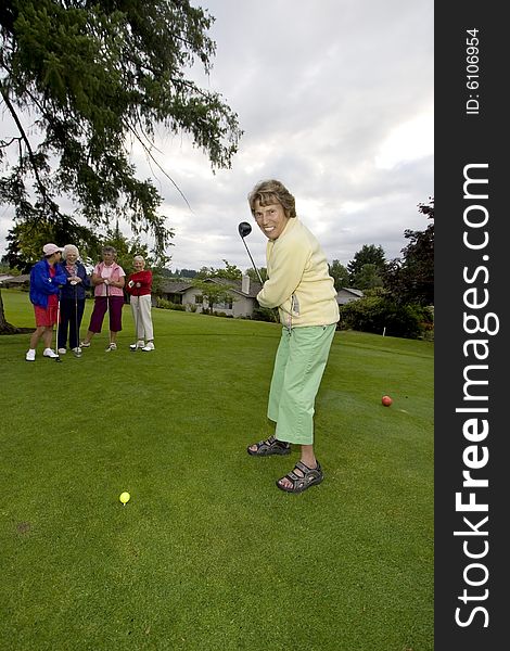 Five elderly women playing golf