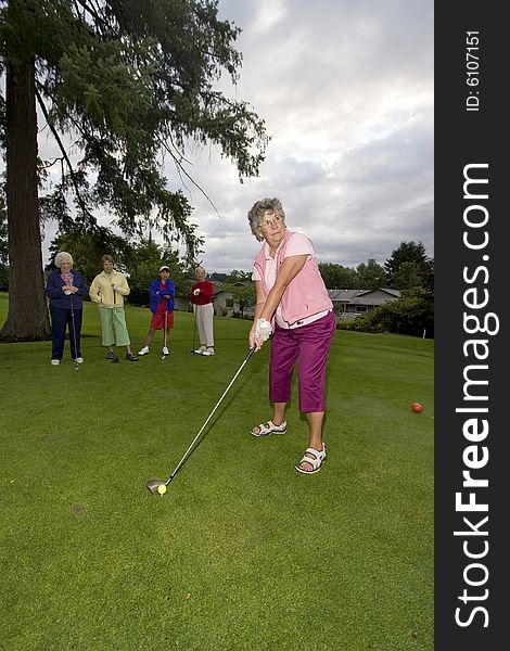 Five elderly women playing golf. Five elderly women playing golf