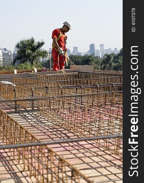 Construction worker stands in new construction site. Vertically framed photo. Construction worker stands in new construction site. Vertically framed photo.