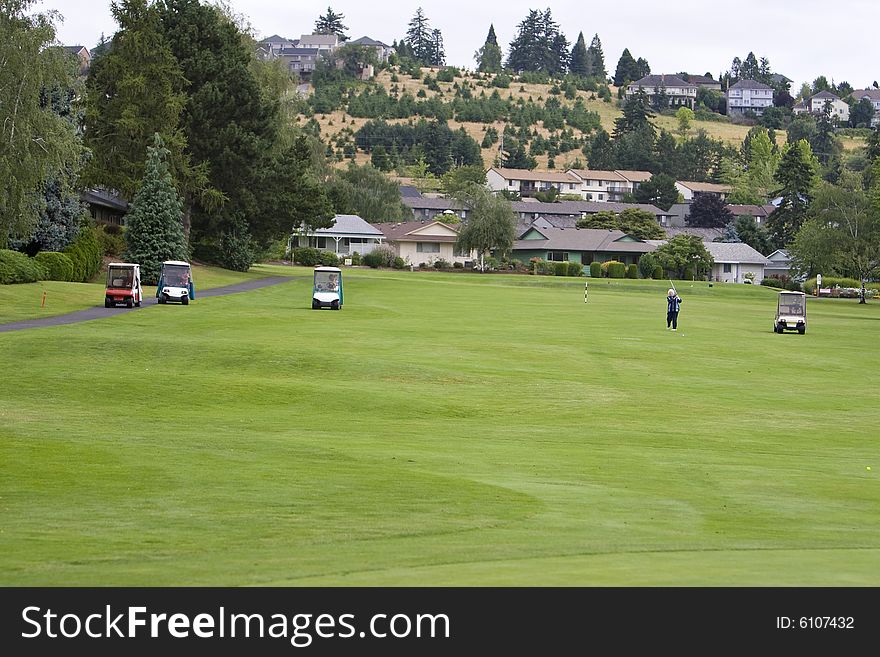 Golf course with golf carts on it. Horizontally framed photo.