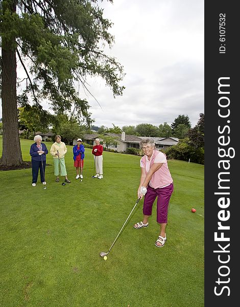 Five happy elderly women playing golf. Vertically framed photo.