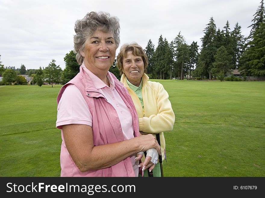Two elderly female golfers smiling. Horizontally framed photo. Two elderly female golfers smiling. Horizontally framed photo.