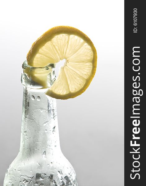 A lemon slice is decorating a bottle. A lemon slice is decorating a bottle.