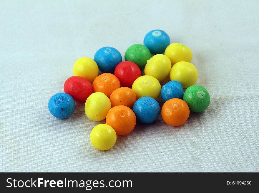 Sweets of different colours isolated against light background