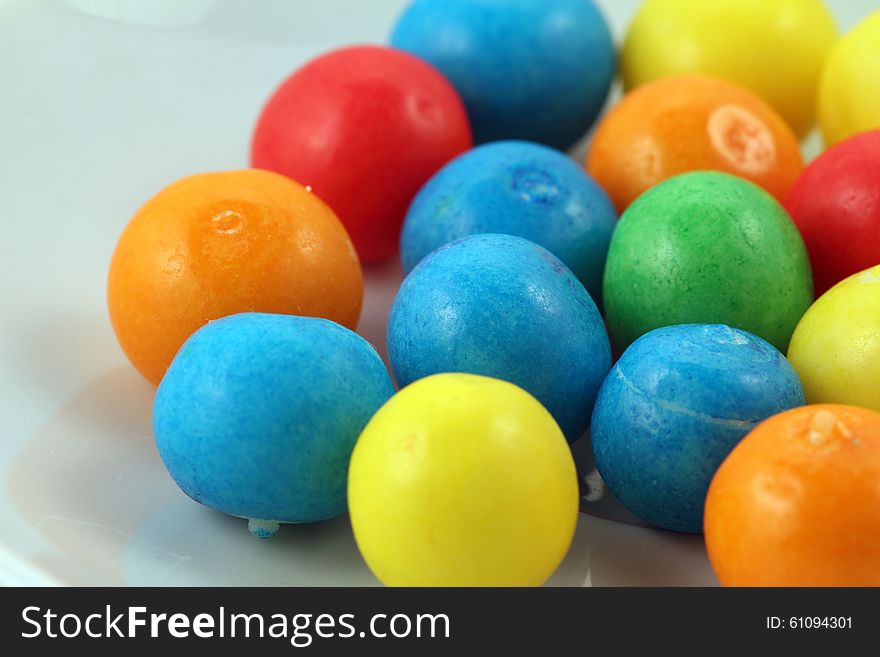 Sweets of different colours isolated against light background