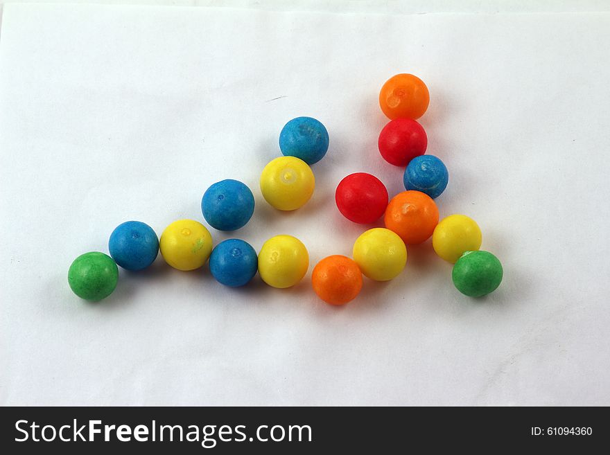 Sweets of different colours isolated against light background