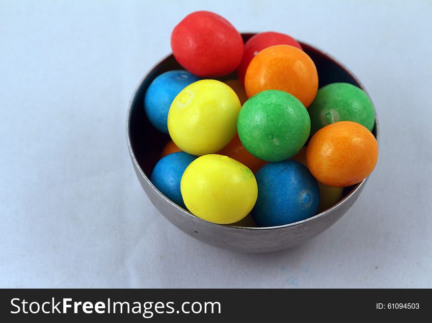 Sweets of different colours in metall bowl