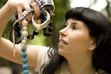 Brunette Holding A Lot Of Beads Royalty Free Stock Photography
