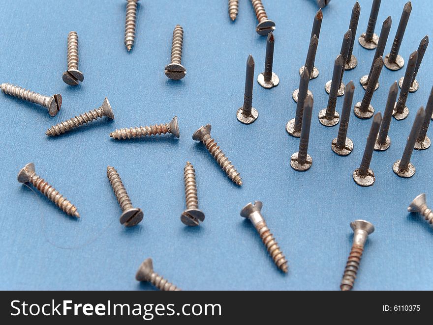 Isolated nails and screws on blue background