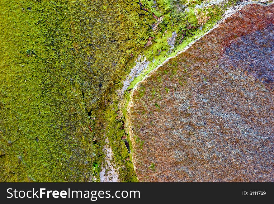 Colored (prevaling green and brown) rough stone surface with lichen