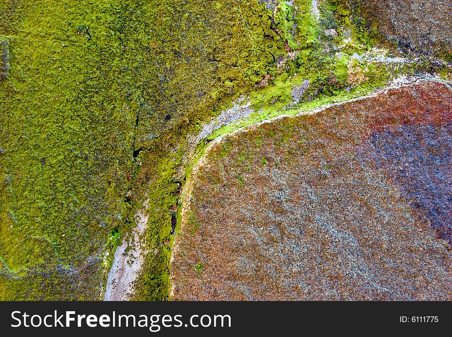 Colored (prevaling green and brown) rough stone surface with lichen