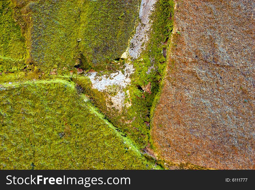 Colored (prevaling green and brown) rough stone surface with lichen