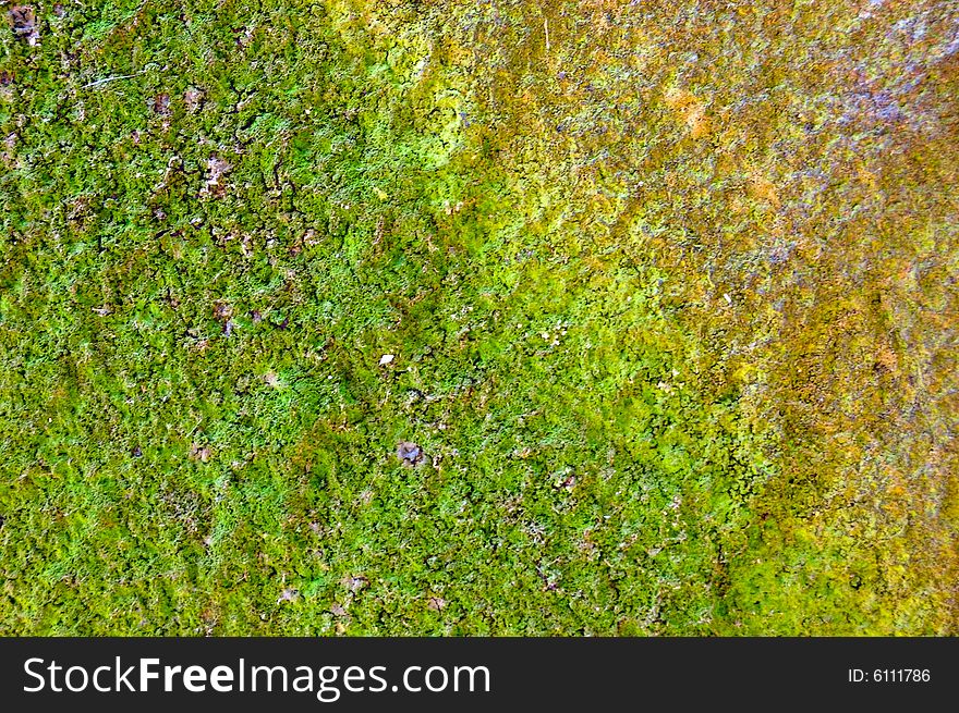 Colored (prevaling green and yellow) rough stone surface with lichen