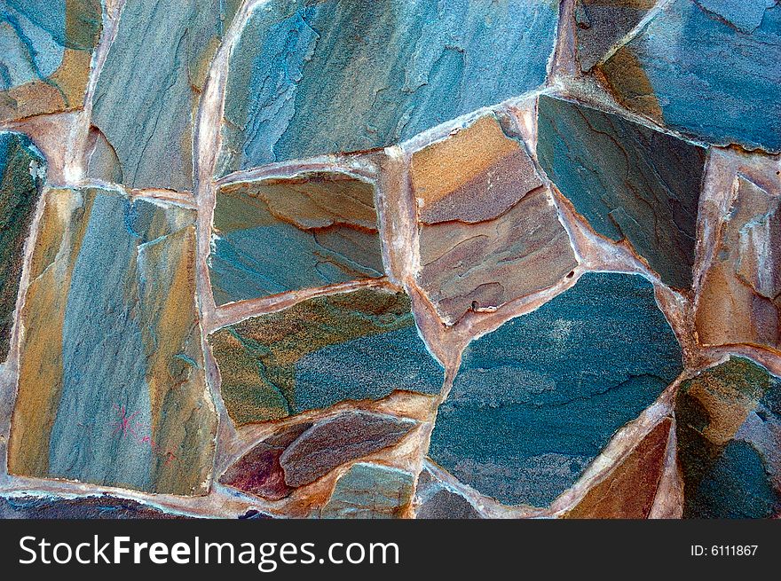 Colored (prevaling blue) rough wall surface made of wild stones. Colored (prevaling blue) rough wall surface made of wild stones