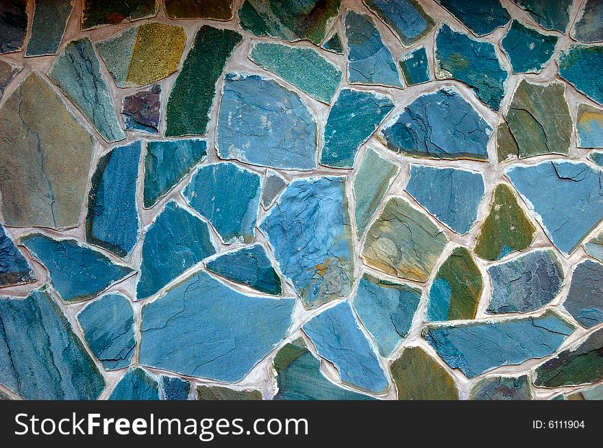 Colored (prevaling blue) rough wall surface made of wild stones. Colored (prevaling blue) rough wall surface made of wild stones