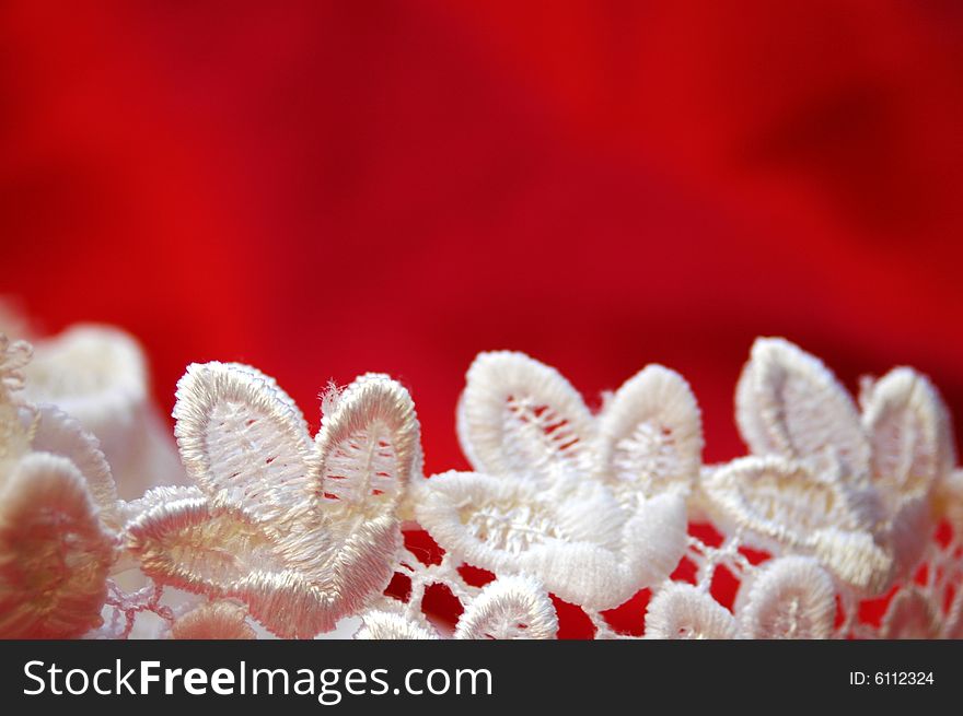 Handmade lace against red satin background