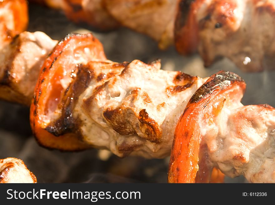 Shish kebab preparation on a brazier. Outdoor picnic. Close up.