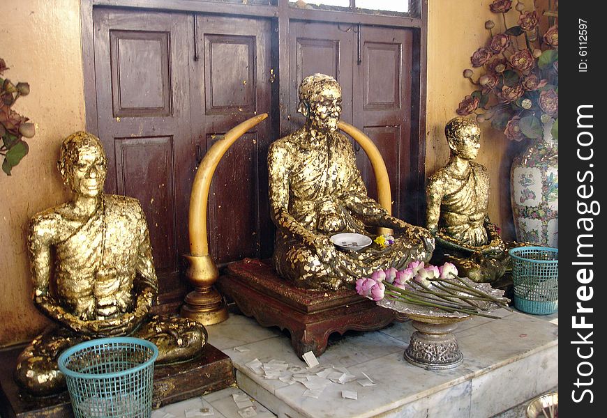 Gilded statues of monks in a shrine in Thailand