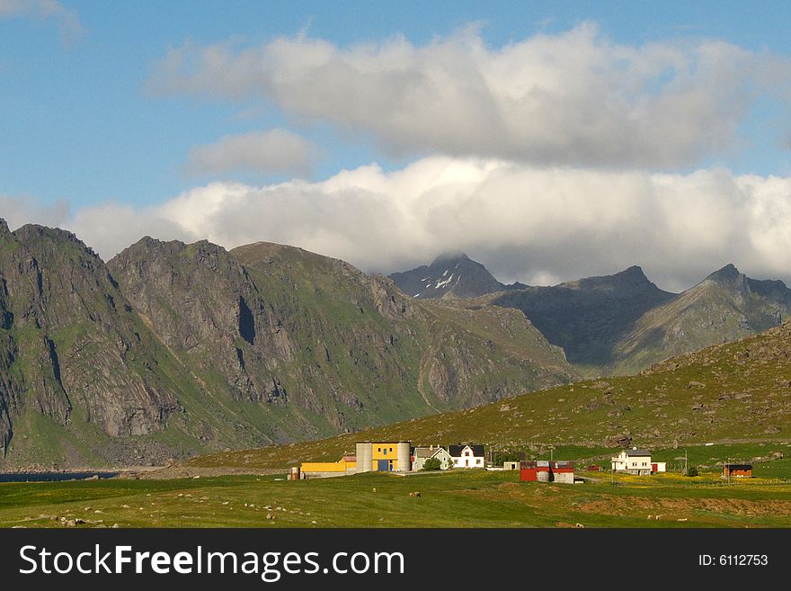 Farms of the village of Uttakleiv protected by the mountains, Lofoten islands Norwegian arctic. Farms of the village of Uttakleiv protected by the mountains, Lofoten islands Norwegian arctic