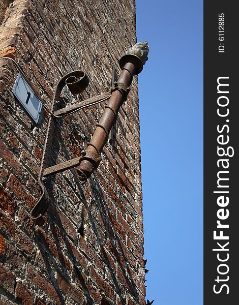 Stands out on the blue sky the torch on the wall of the castle