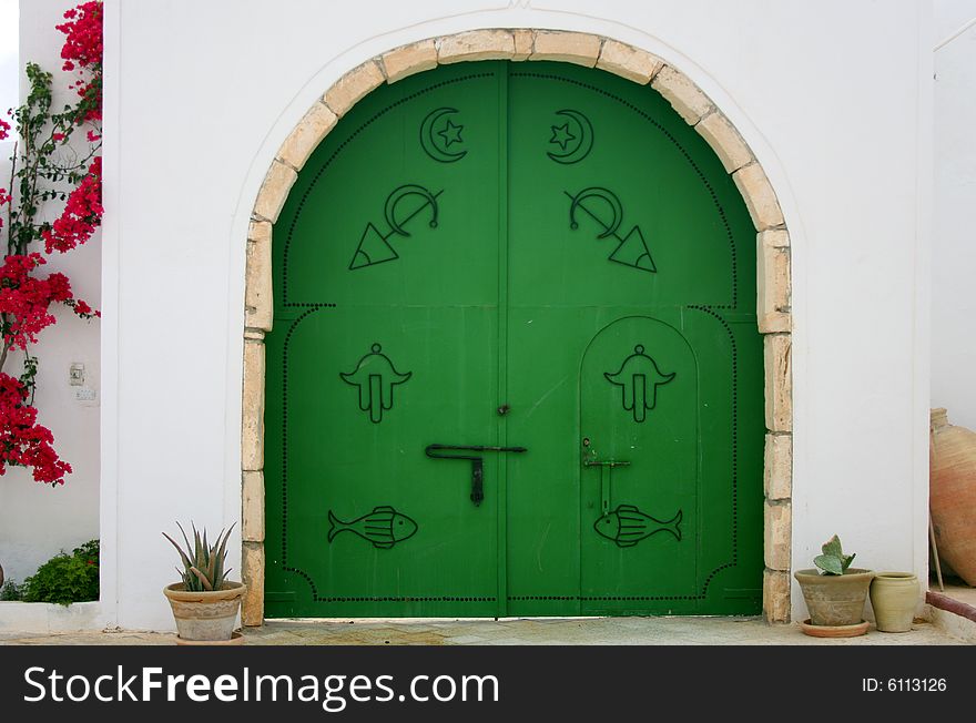 Green gate with arabic symbols.