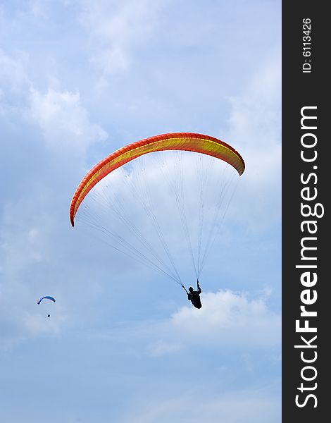 Two paragliders silhouetted against summer sky. Two paragliders silhouetted against summer sky