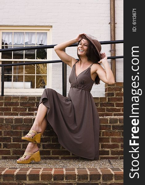 Beautiful woman trying to stop the wind from blowing off her hat