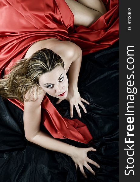 Blonde girl with red silk that seeks the pleasure. Blonde girl with red silk that seeks the pleasure